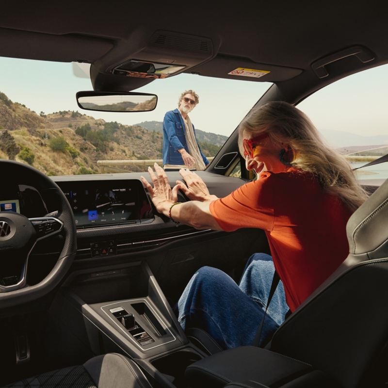 Eine Frau genießt ihre Zeit in ihrem VW Auto mit modernen Infotainment-Systemen – Volkswagen Interieur
