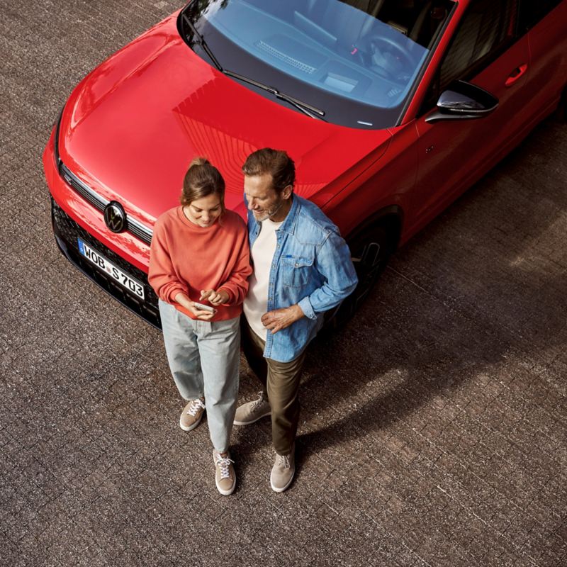 Mann und Frau an einem VW Auto aus der Vogelperspektive