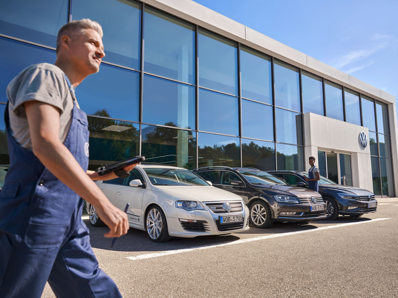 VW mechanic walking at service centre with tablet