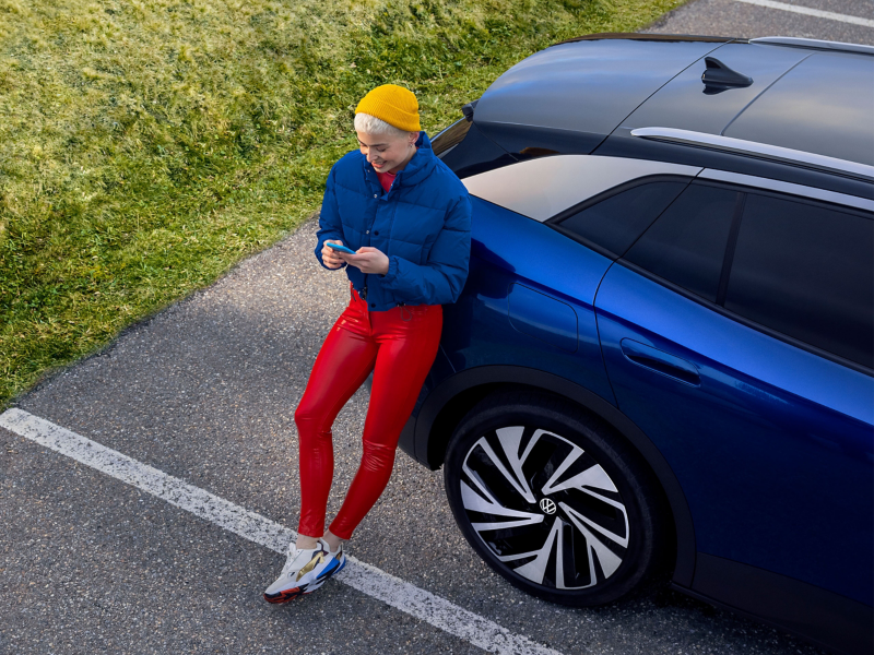 Une jeune femme appelle le service d’assistance en cas de panne et d’accident – Garantie de mobilité pour votre Volkswagen 