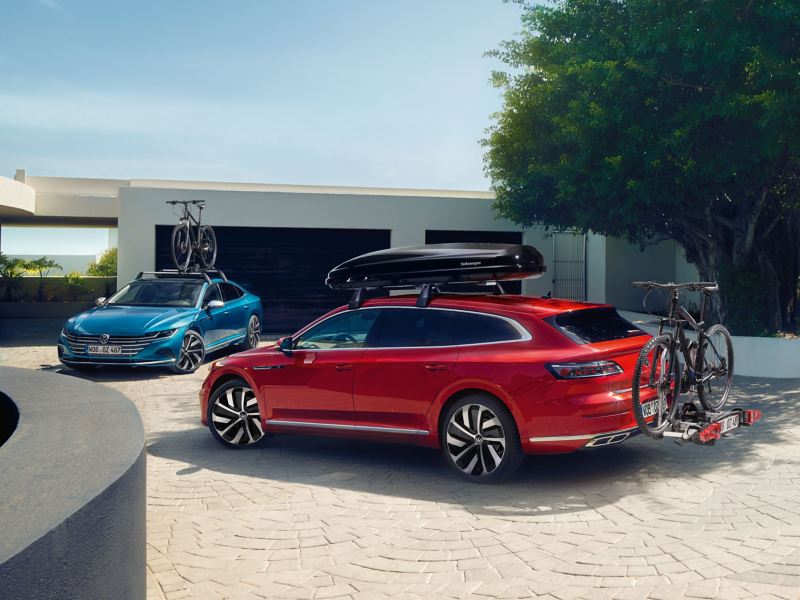 Zwei Volkswagen mit Dachbox, Fahrradträger und Fahrradhalter – praktisches VW Zubehör
