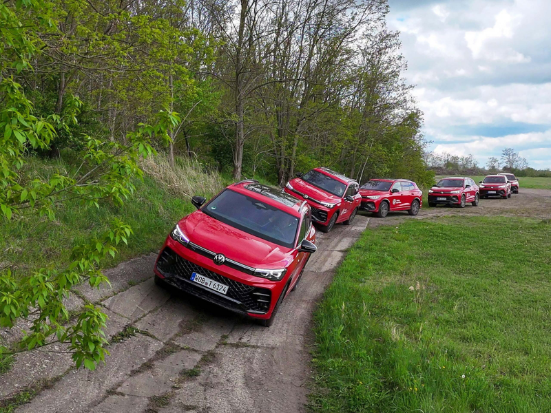 Mehrere VW Tiguan fahren hintereinander auf einer Teststrecke