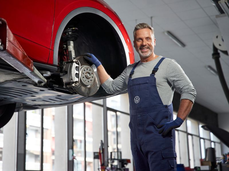 Collaborateur d’atelier Volkswagen à côté d’un frein d’origine Volkswagen sur une Volkswagen ID.5 GTX