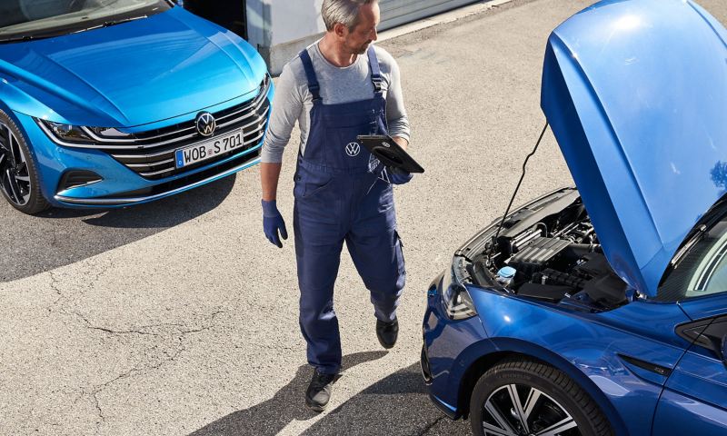 A VW service employee checks a VW car – repairs and checks