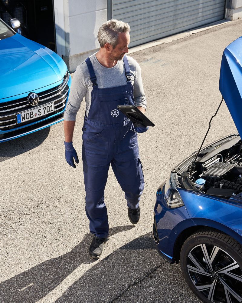 Un profesional del Servicio Oficial de Volkswagen revisa un coche. Reparaciones y comprobaciones.