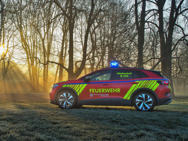 VW Notfallfahrzeug steht vor einem Wald, Sonne scheint durch die Bäume