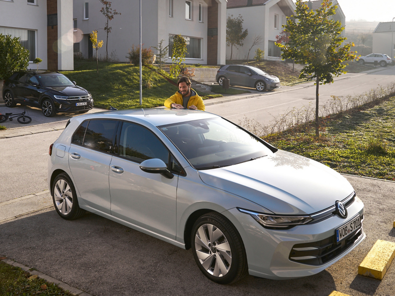 Mann neben Auto mit VW Zubehör