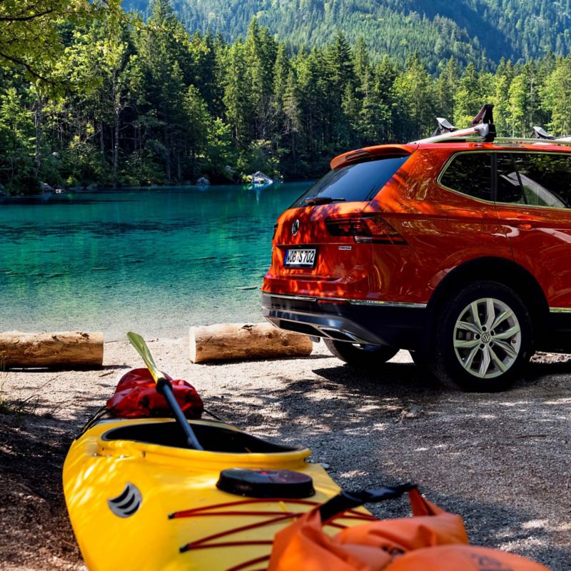 A Tiguan Allspace with a kayak stands by a lake
