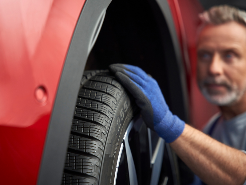 Un employé du service Entretien VW vérifie un pneu VW à la recherche d’éventuels dommages