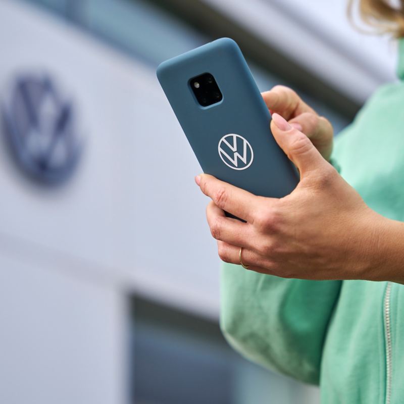 Frau mit Smartphone auf der Suche nach Volkswagen Partner Werkstatt