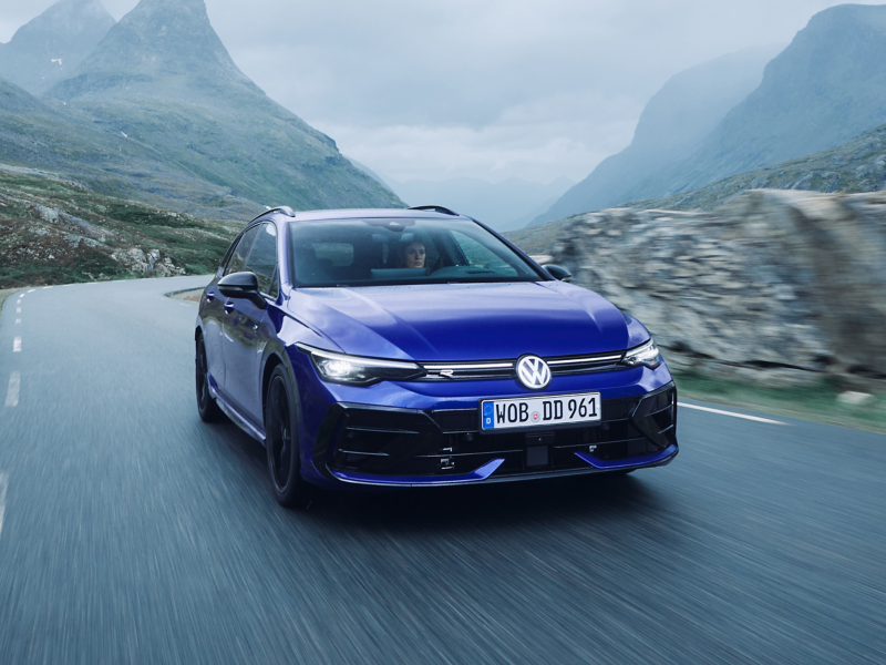VW Golf R unterwegs auf einer Straße, die von Bergen umgeben ist
