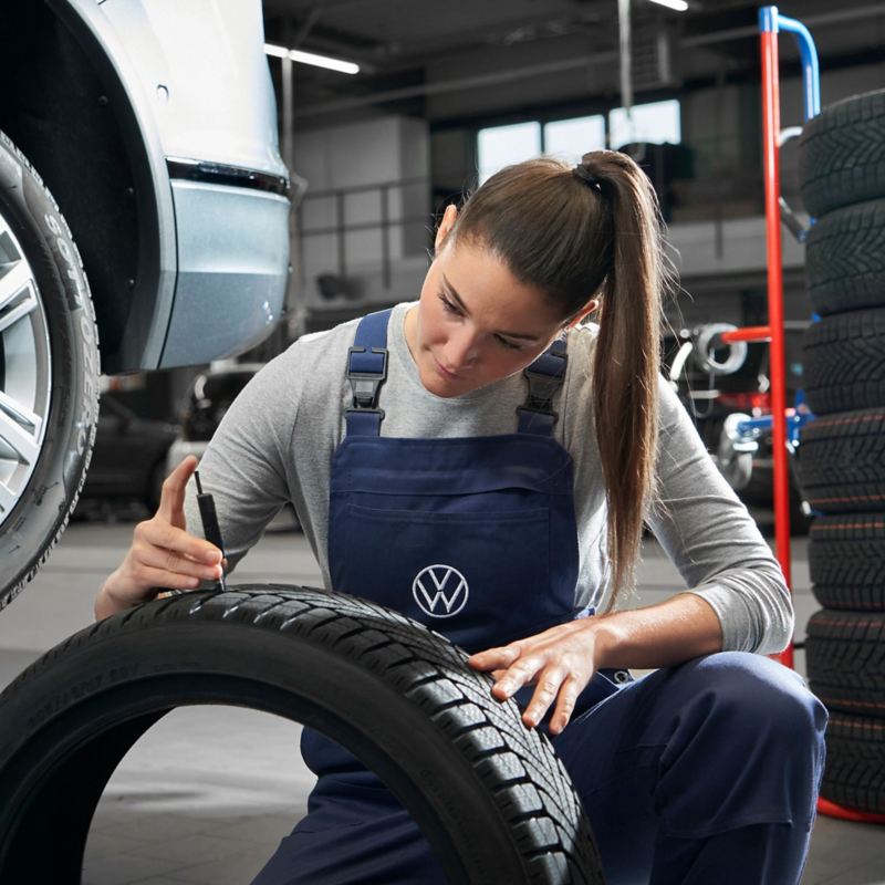 VW service employee checks profile of a VW tyre