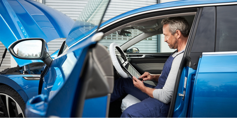 VW technician running diagnostic on vehicle.