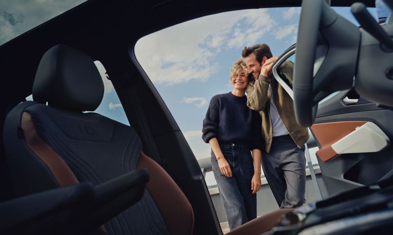 A couple next to the open driver’s door of the Volkswagen