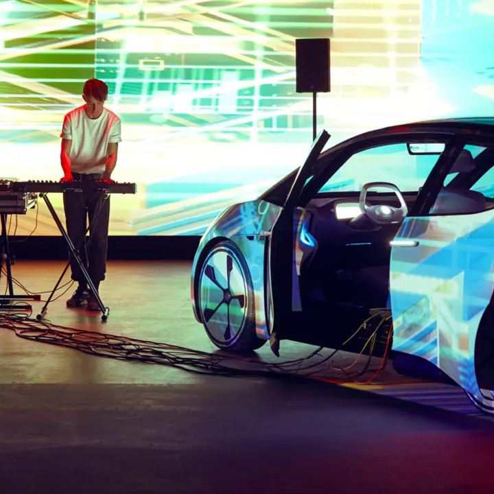 Artista Bercubs realizando una sesión en un espacio cerrado junto a un Volkswagen ID. Neo