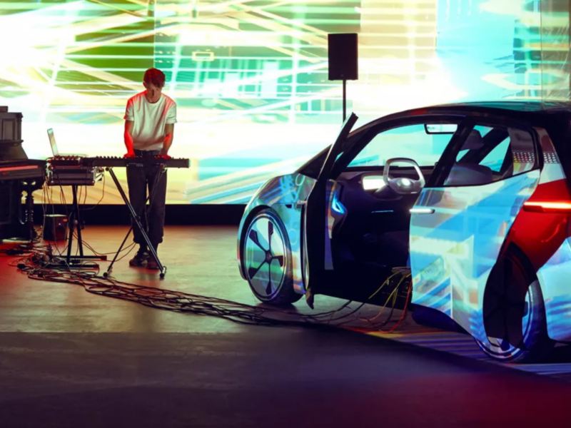 Artista Bercubs realizando una sesión en un espacio cerrado junto a un Volkswagen ID. Neo