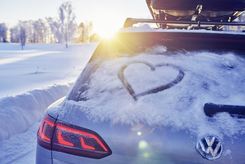 En snötäckt bakdel på en Volkswagen syns på bakrutan och någon har ritat ett hjärta i snön
