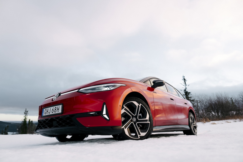 En röd VW ID.7 sedd underifrån med fokus på framdäcket och fälgen