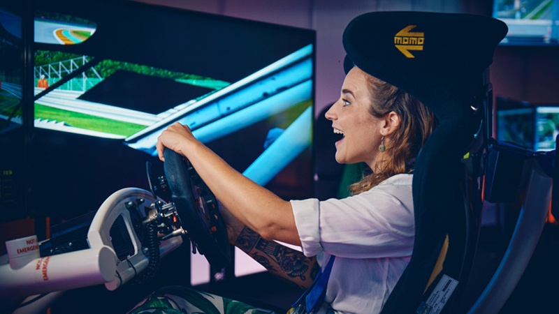 Eine Frau fährt in einem Autosimulator.