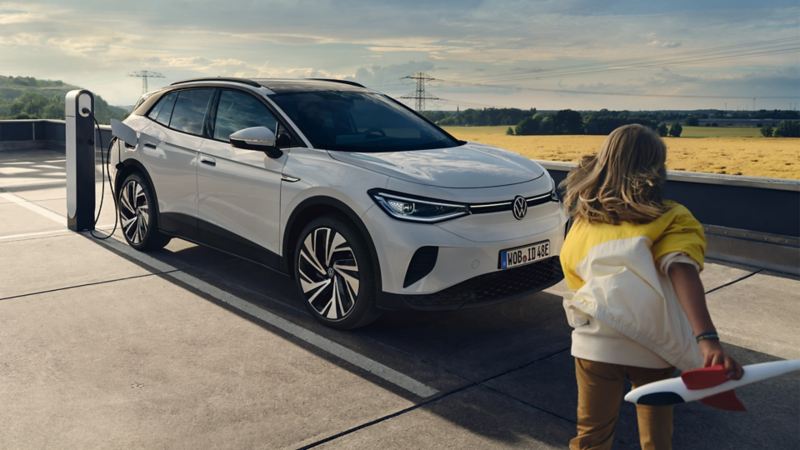 Un enfant s’avance vers une VW ID.4 en train de charger.