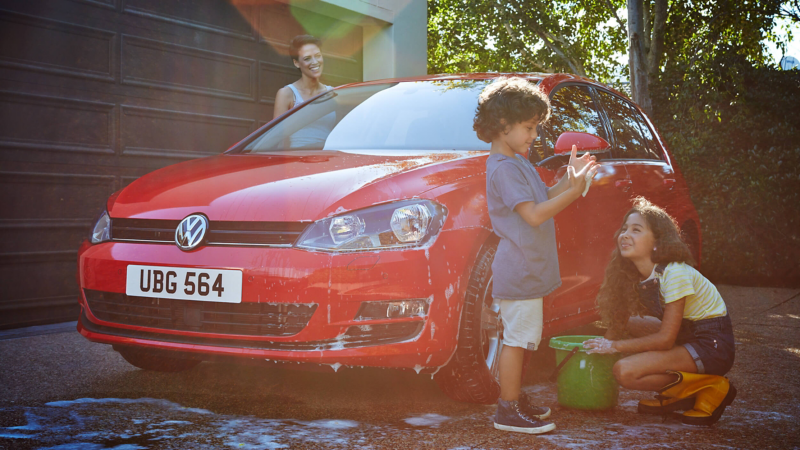 A family washing a VW Golf