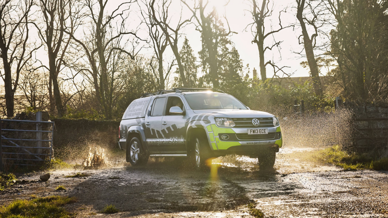 Photo showing an Amarok driving through a muddy road. 