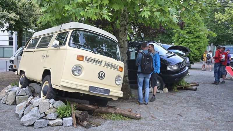 Photo showing an artistic display of a VW Van and people standing next to it. 
