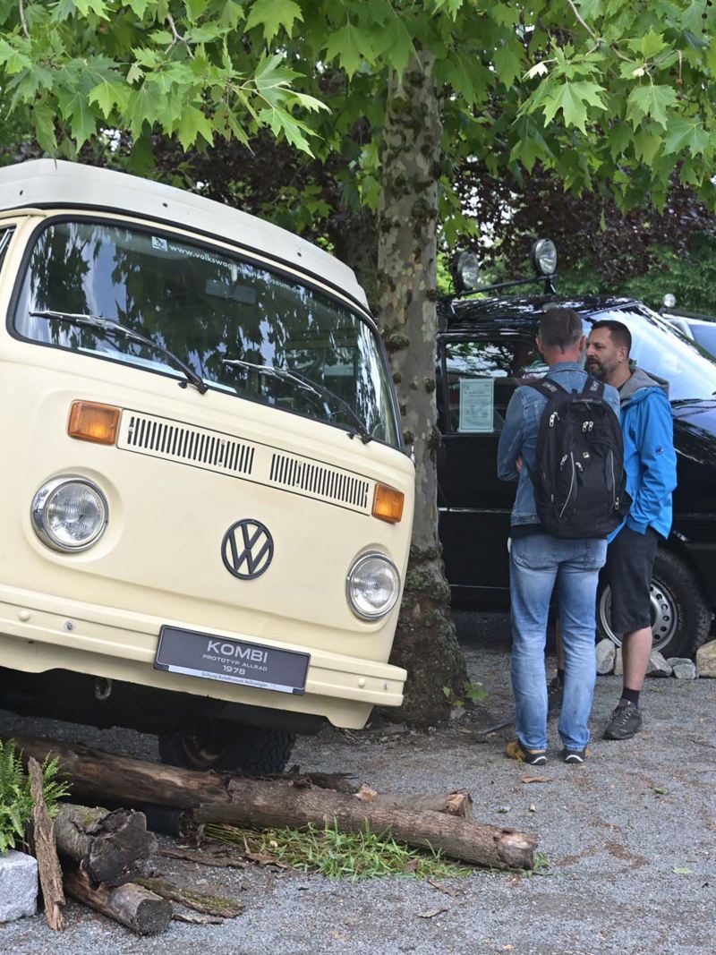 Photo showing an artistic display of a VW Van and people standing next to it. 