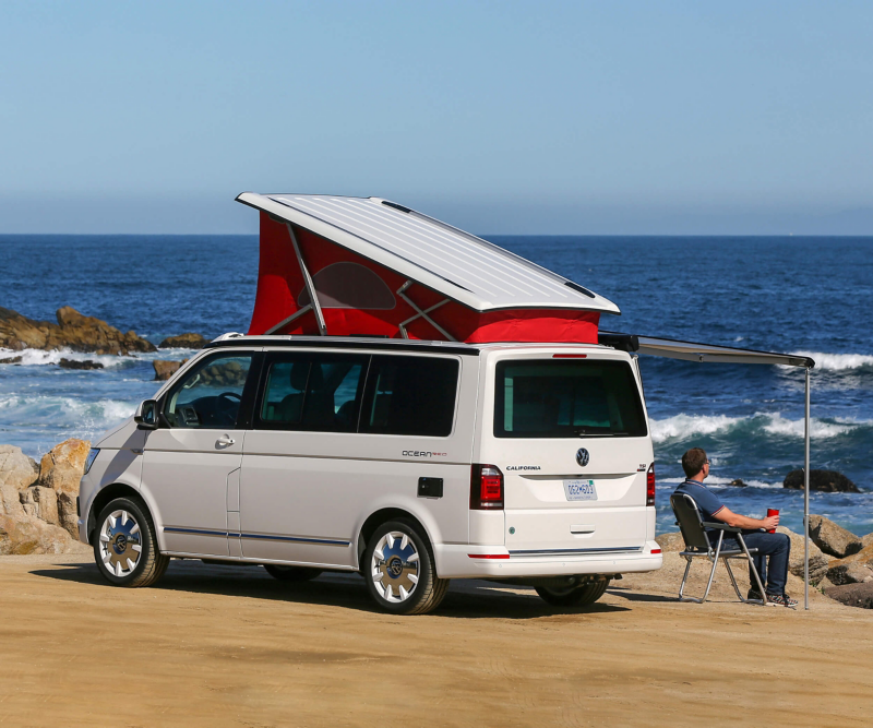 man sat outside VW California by ocean