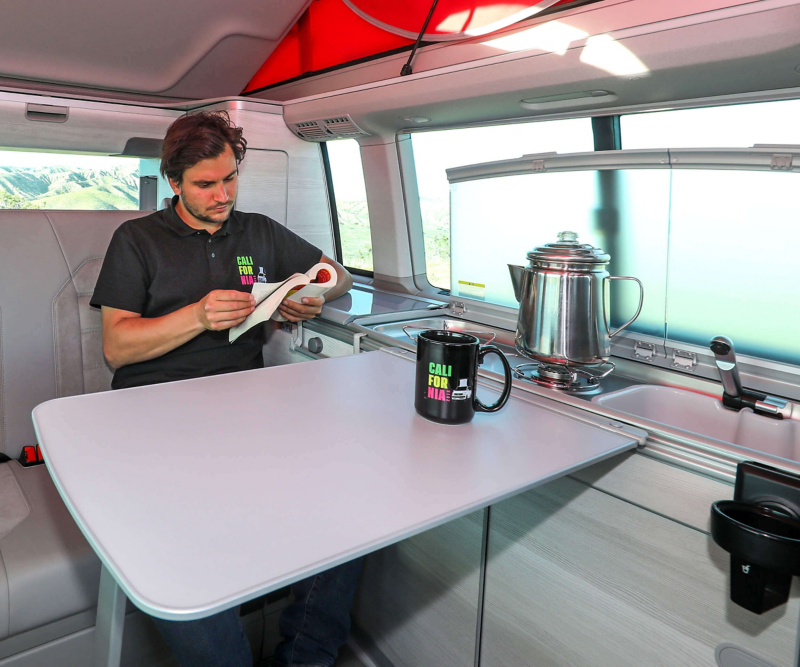 man reading in living area of VW California