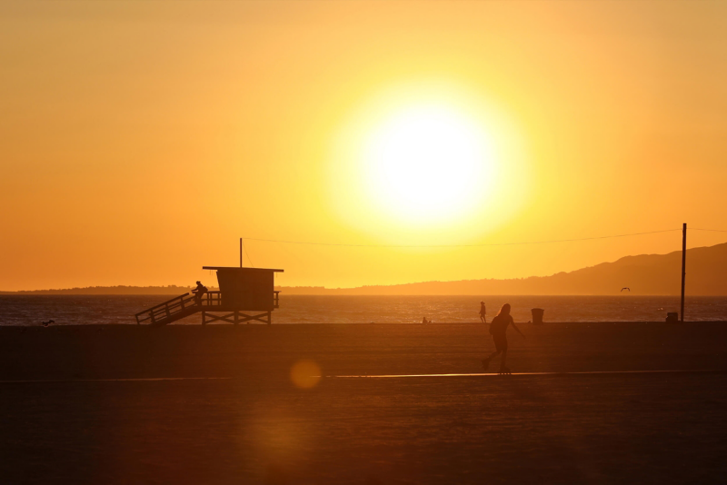 People playing on California beach at sunset