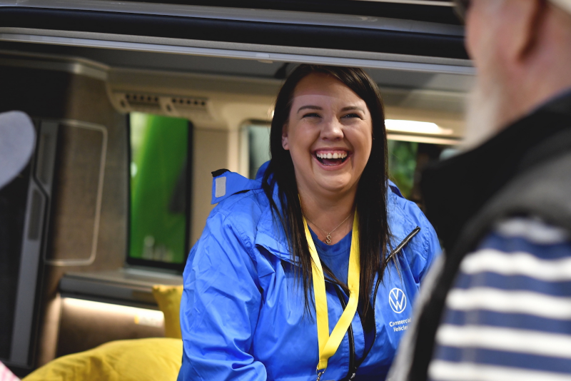 Photo showing a smiling VW colleague inside a camper van at the CCM show. 