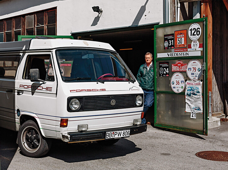 Man standing by Porsche camper van