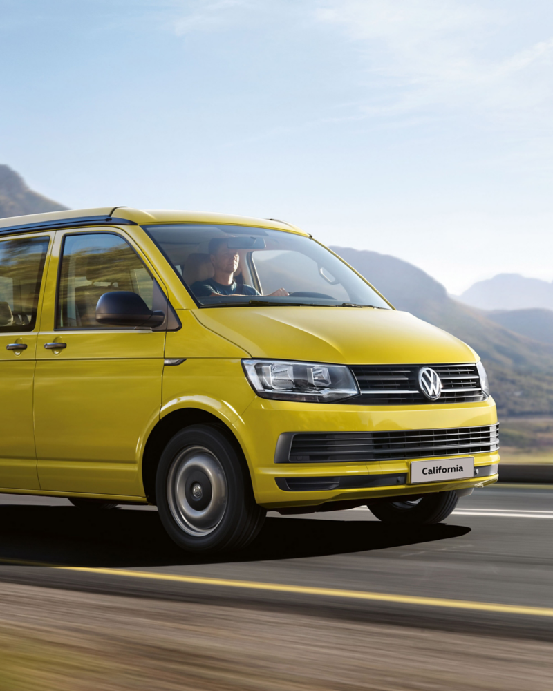 Yellow VW California camper van on mountain road