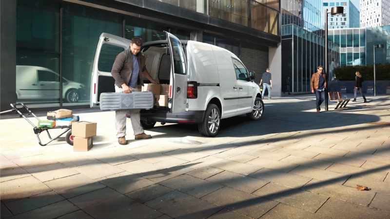 Workman putting tools into van