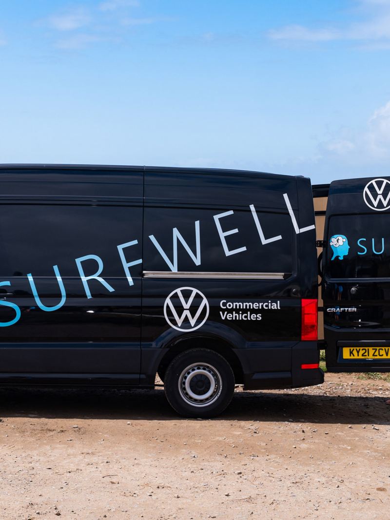 Surfwell team members loading surfboards into a VW van. 