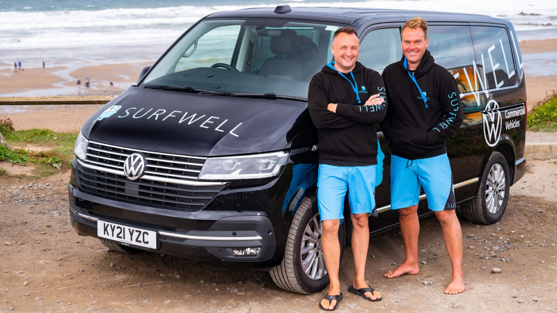 Two Surfwell team members standing in front of a VW van.
