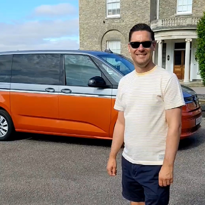 Photo showing Paul Tremain standing infront of a VW Multivan. 