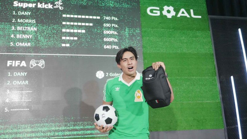 Asistente a lanzamiento de Volkswagen GOAL sostiene premios ganados en una activación.