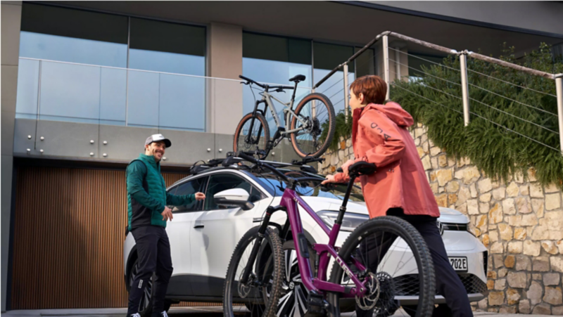 Man and woman loading bikes onto roof rack of ID.4.