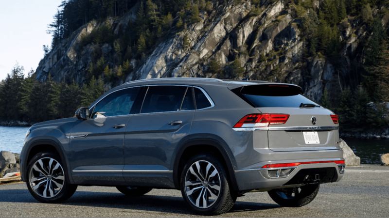 A Pure Grey 2022 Volkswagen Atlas Cross Sport SUV parked next to the shore.