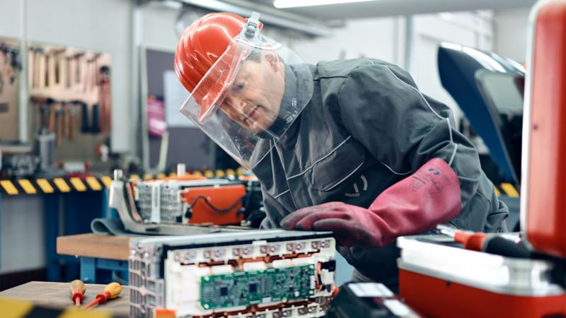 Ein Mann arbeitet in einer Werkstatt an einer Batterie