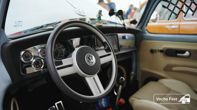 Interior de un Volkswagen Vocho antiguo, con asientos y cubiertas adaptadas. 