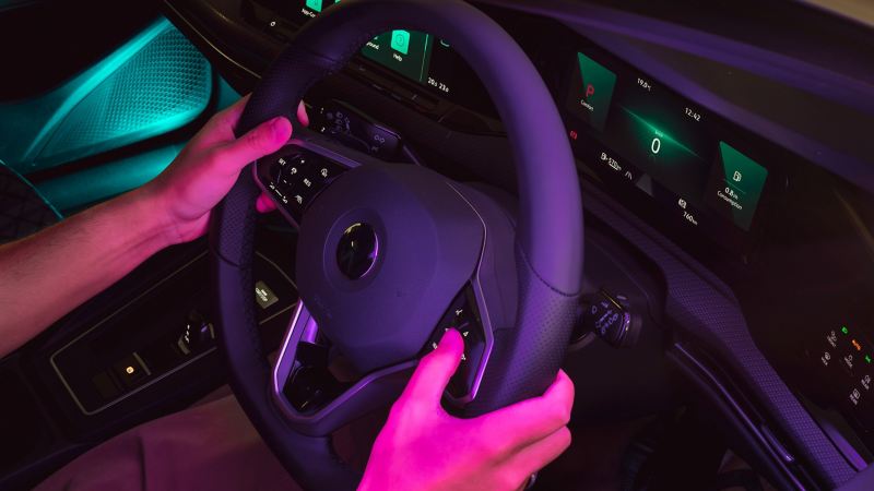 Man olding the Steering wheel of the Volkswagen Car.