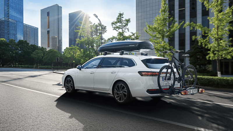 VW Passat z bagaznikiem rowerowym i dachowym na ulicy w mieście