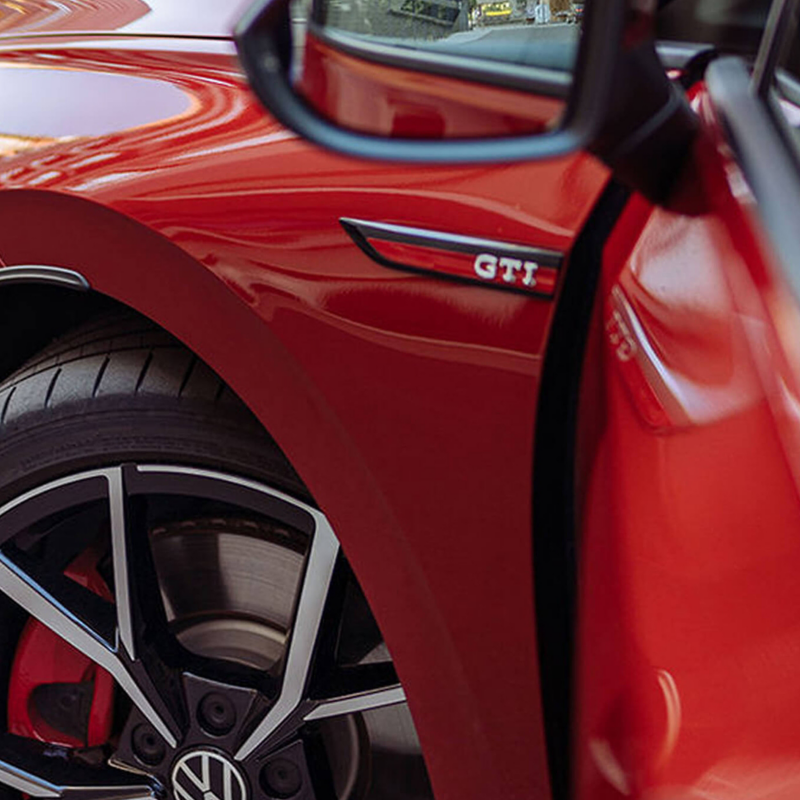 Close up photo showing the door and front wheel of a VW Golf GTI. 