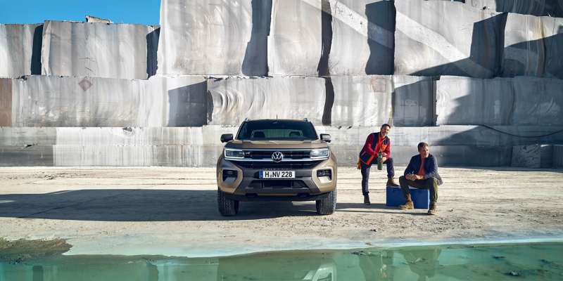 Frontansicht des VW Amarok in einem Marmorsteinbruch, daneben Pause machende Bauarbeiter.