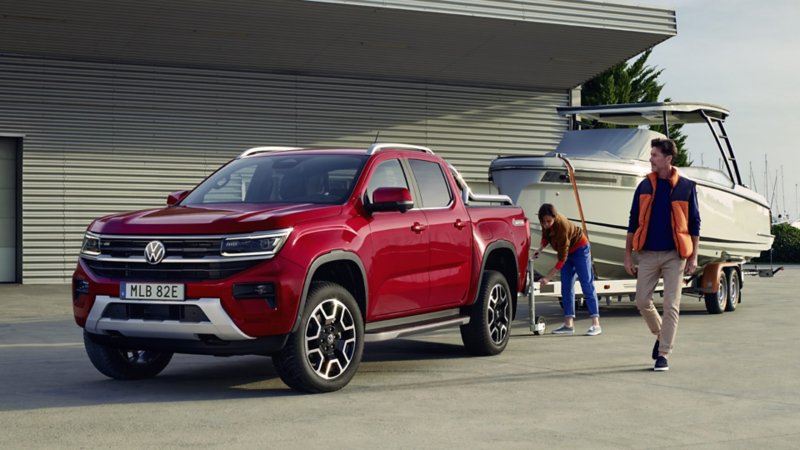 Röd VW Amarok med båt på släp