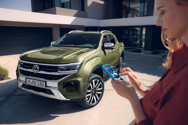 El VW Nuevo California aparcado en la orilla junto a dos personas.