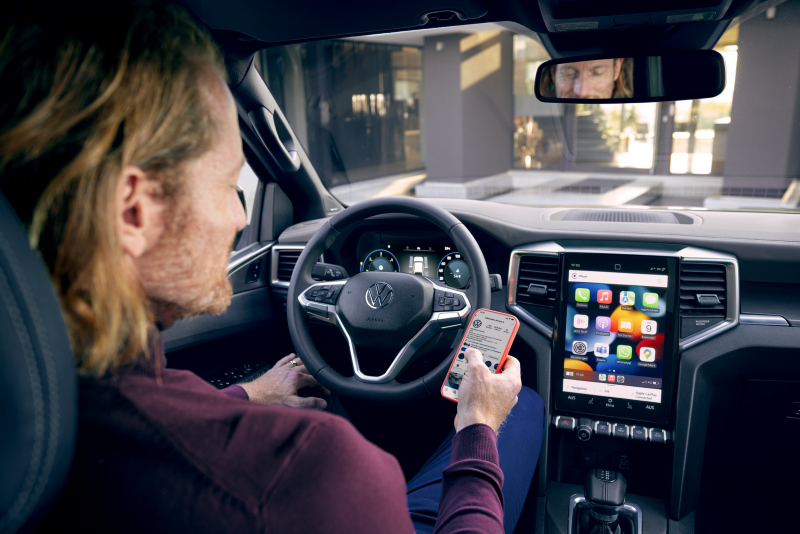 Tiguan rouge en circulation avec un coffre de toit.